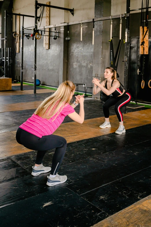two women doing squat exercises in a crossfit gym, by Adam Marczyński, pexels contest winner, square, basic background, on stage, panorama