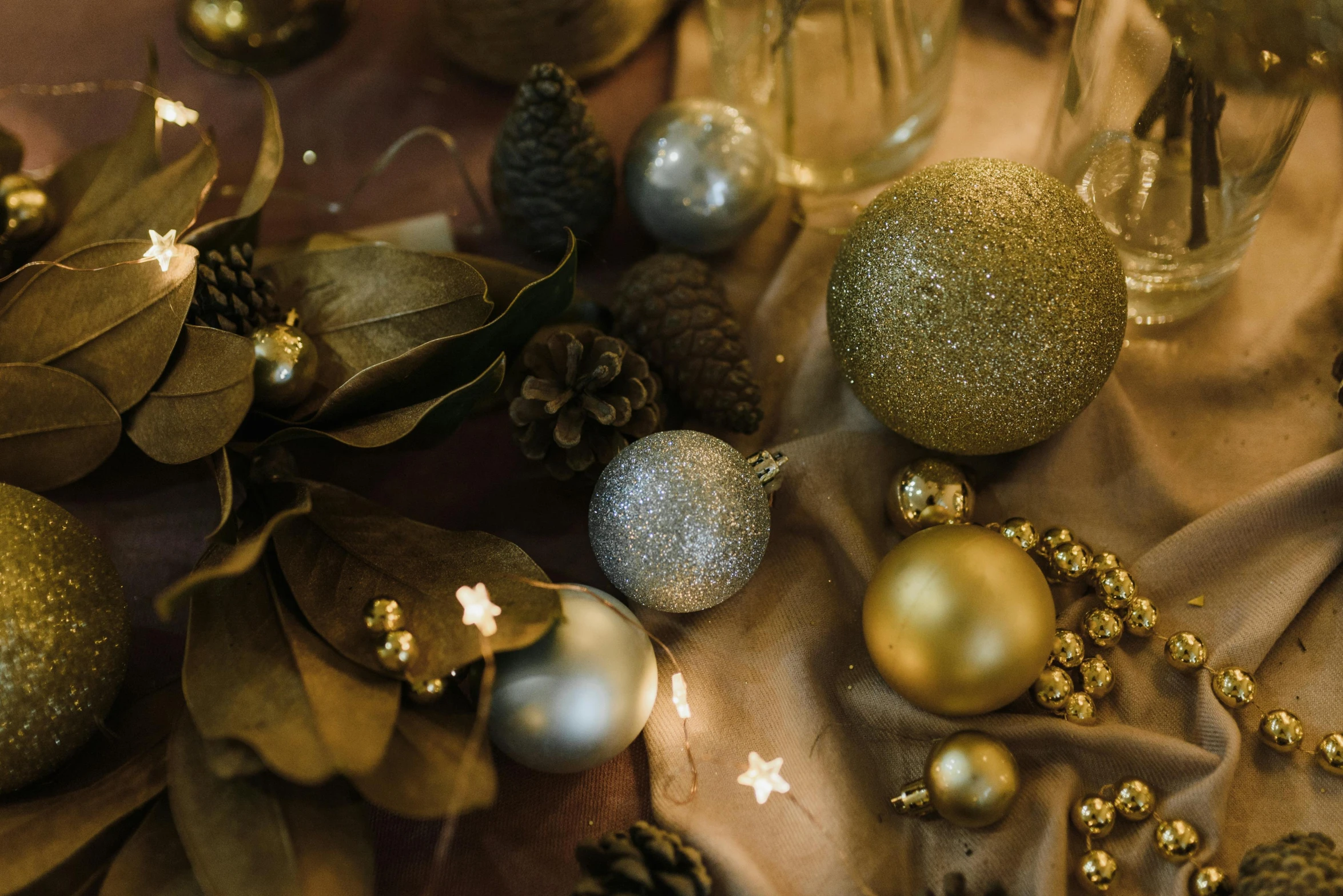 a table topped with gold and silver ornaments, by Julia Pishtar, trending on pexels, golden orbs and fireflies, brown, thumbnail, detail shot