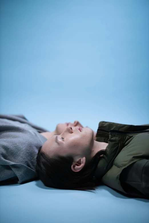 a man laying on top of a bed next to a remote control, poster art, by Jaakko Mattila, unsplash, hyperrealism, bradley james and colin morgan, looking upwards, looking at each other mindlessly, blue sky