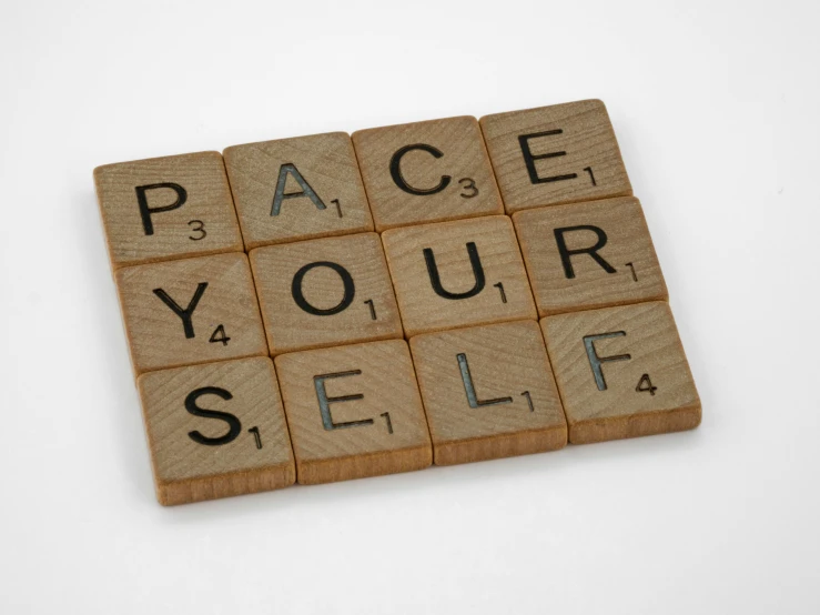 a wooden block with the words race your self written on it, by Rachel Reckitt, unsplash, minimalism, squares, at peace, multiplayer set-piece, 1920s photograph