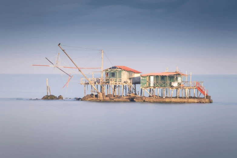 a boat sitting on top of a body of water, by Ibrahim Kodra, pexels contest winner, fantastic realism, houses on stilts, medium format. soft light, mining outpost, 'untitled 9 '