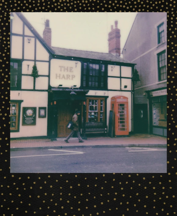 a man walking down a street past a tall building, a polaroid photo, by IAN SPRIGGS, unsplash contest winner, a multidimensional cozy tavern, harp, harry, shop front