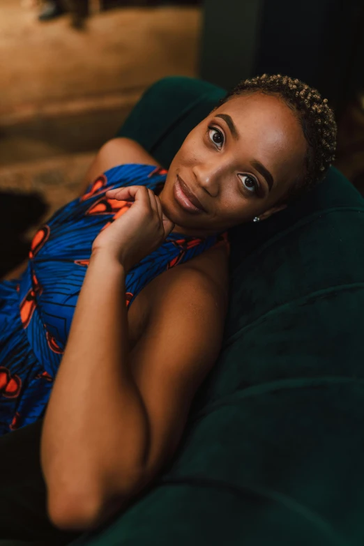 a woman laying on top of a green couch, a portrait, by Chinwe Chukwuogo-Roy, pexels contest winner, renaissance, relaxing and smiling at camera, ashteroth, avatar image, casually dressed