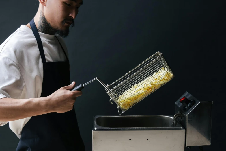 a man standing in front of a fryer filled with corn, inspired by Kanō Naizen, unsplash, hyperrealism, pulling the move'derp banshee ', detailed product shot, cast, rectangle