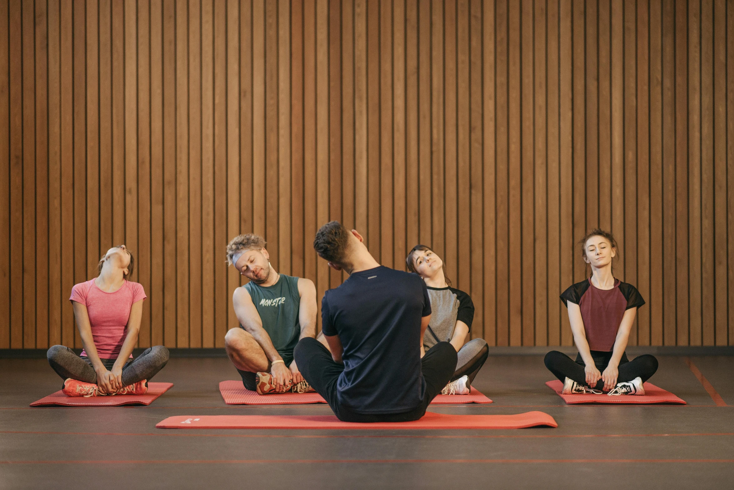 a group of people sitting on top of a red mat, by Nina Hamnett, unsplash, hurufiyya, dim dingy gym, brown, calmly conversing 8k, animation