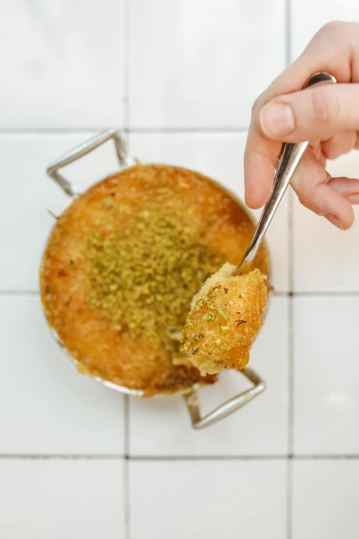 a person holding a spoon over a bowl of food, arabesque, deep fried, round-cropped, top down, cake