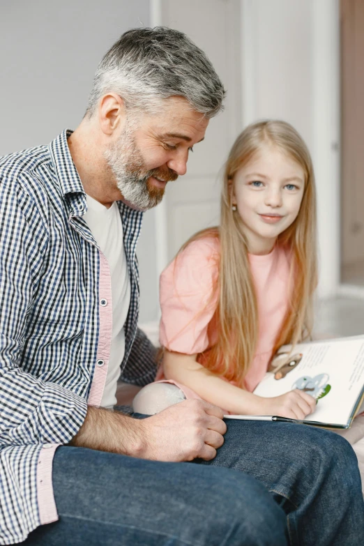 a man reading a book to a little girl, pexels contest winner, looking to the right, profile image, casually dressed, promo image