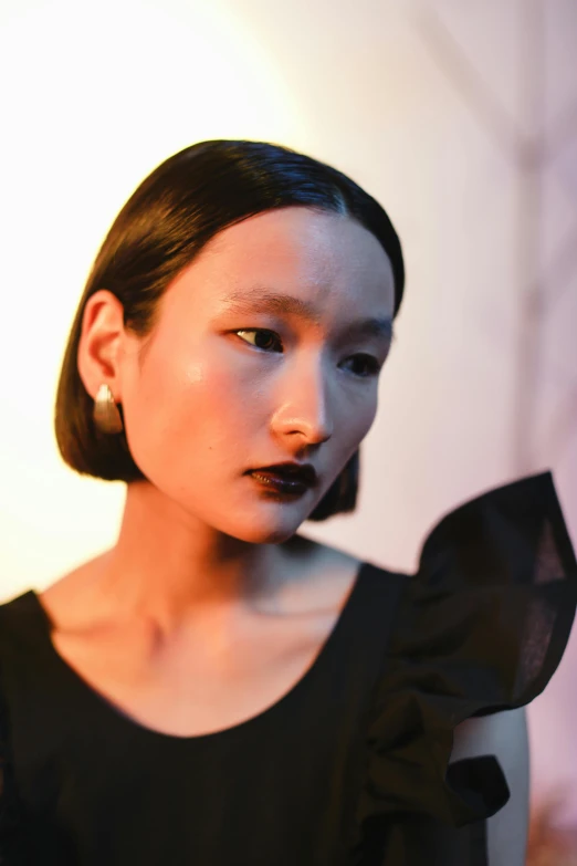 a woman in a black dress posing for a picture, inspired by Tadashi Nakayama, visual art, wearing pearl earrings, dark lipstick, looking away from the camera, mei-ling zhou