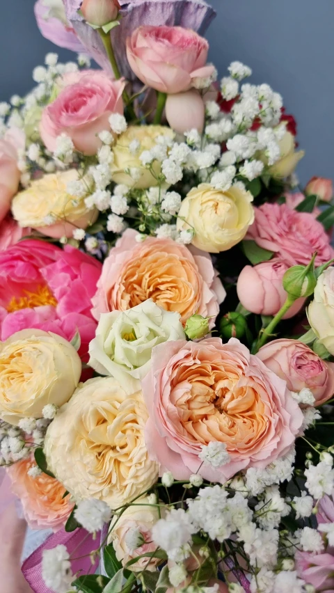 a woman holding a bouquet of flowers in her hands, lots of pastel colour, zoomed in, up-close, bubbly