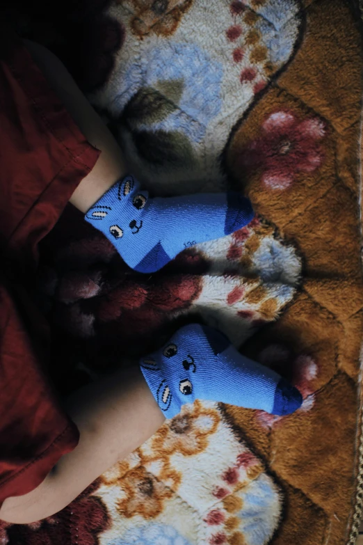 a close up of a person wearing socks with cats on them, an album cover, by Lucia Peka, pexels, ((blue)), young child, night mood, square