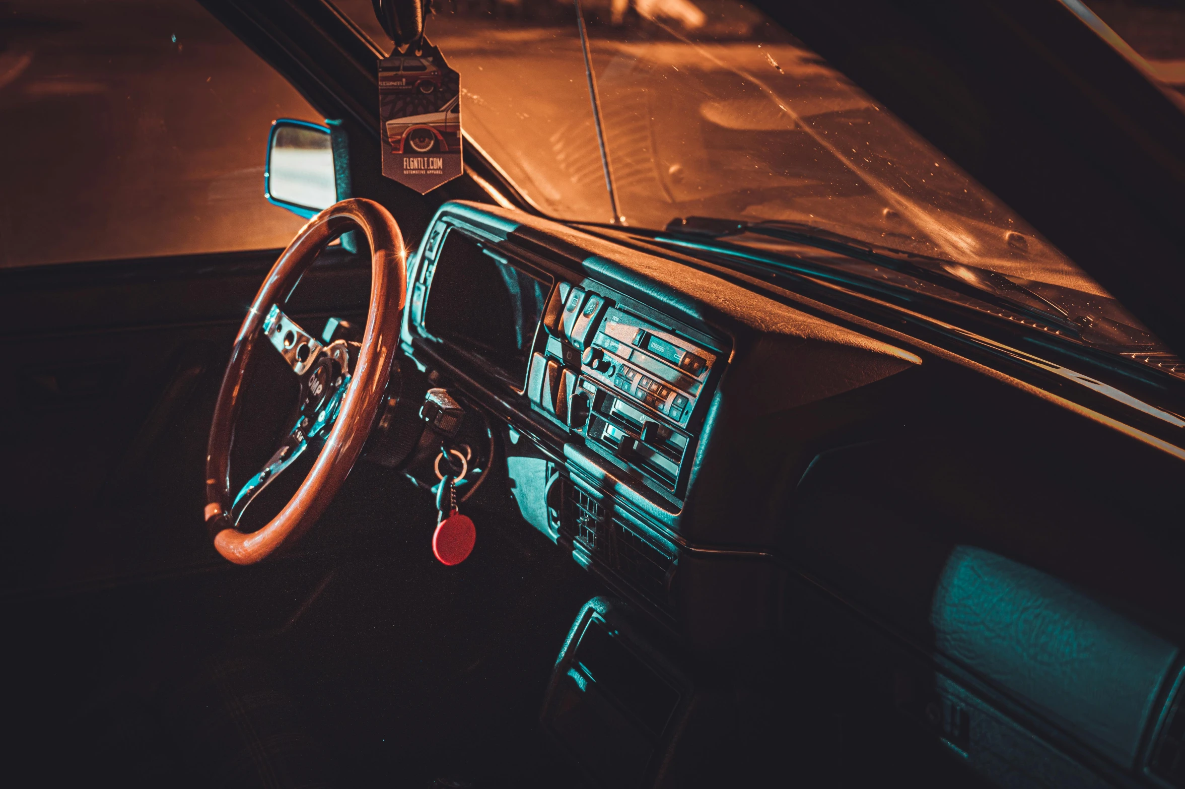 a close up of a steering wheel in a car, an album cover, inspired by Elsa Bleda, unsplash, auto-destructive art, square, dimly lit interior room, 80s photo, nighttime scene