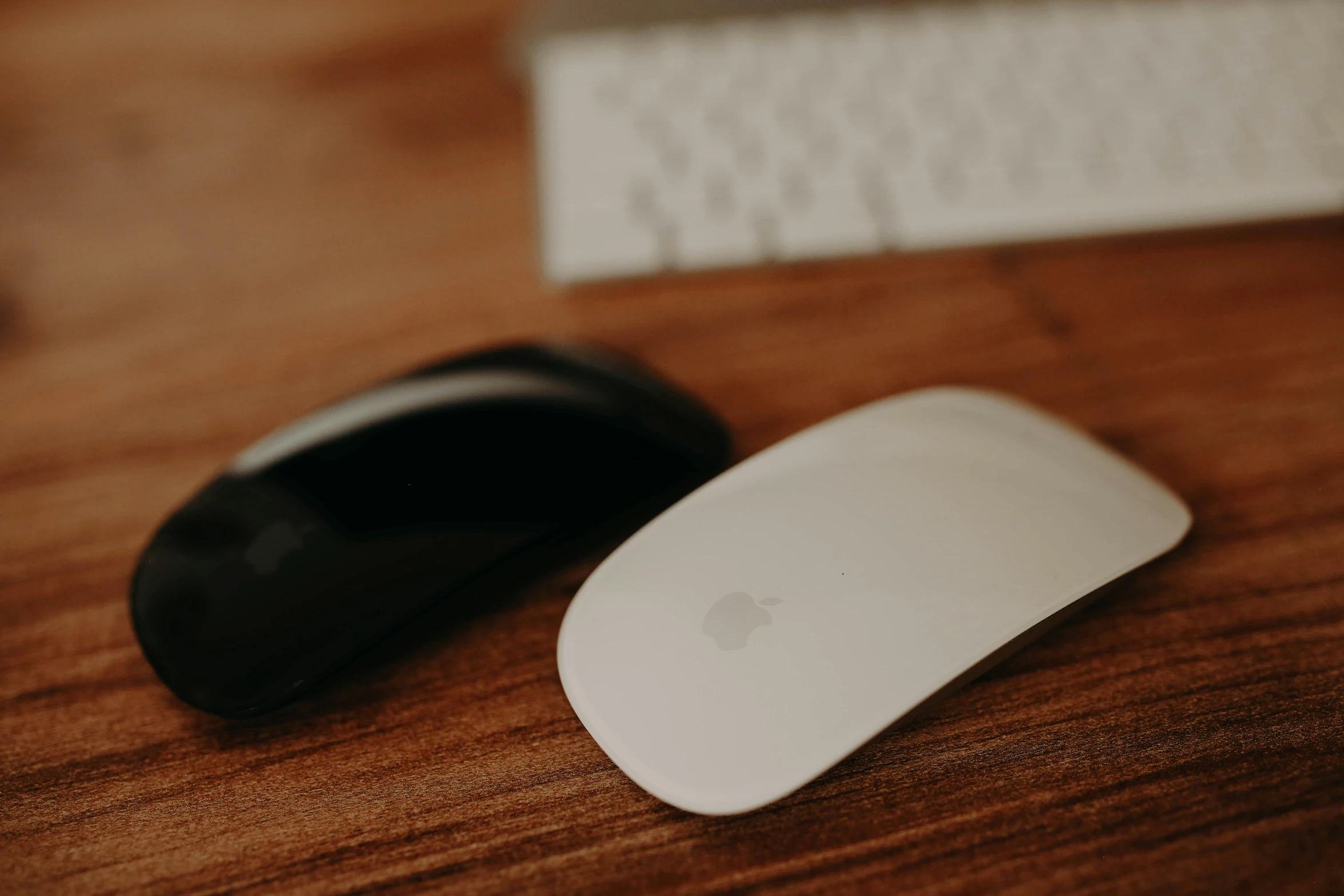 a computer mouse sitting on top of a wooden desk, a picture, unsplash, jony ive, white sleeves, male and female, background image