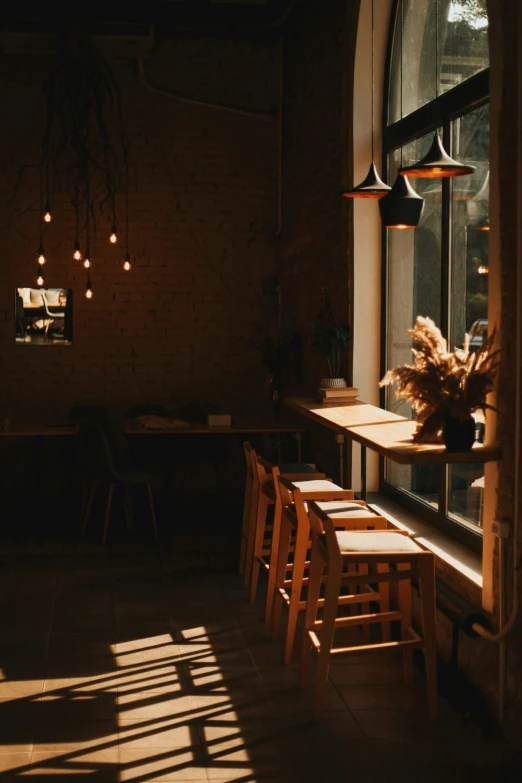 the sun shines through the windows of a restaurant, pexels contest winner, light and space, cafe lighting, empty stools, dimly lit scene, soft lighting |