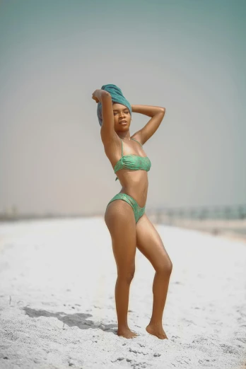 a woman in a green bikini standing on a beach, a colorized photo, trending on pexels, black young woman, slide show, gif, pastel'