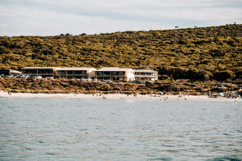 a group of people standing on top of a beach next to a body of water, carrington, viewed from the ocean, ten flats, flatlay