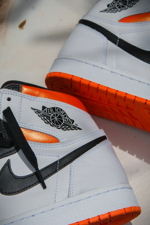 a pair of shoes sitting on top of a table, inspired by Jordan Grimmer, orange details, zoomed in shots, jdm, up close