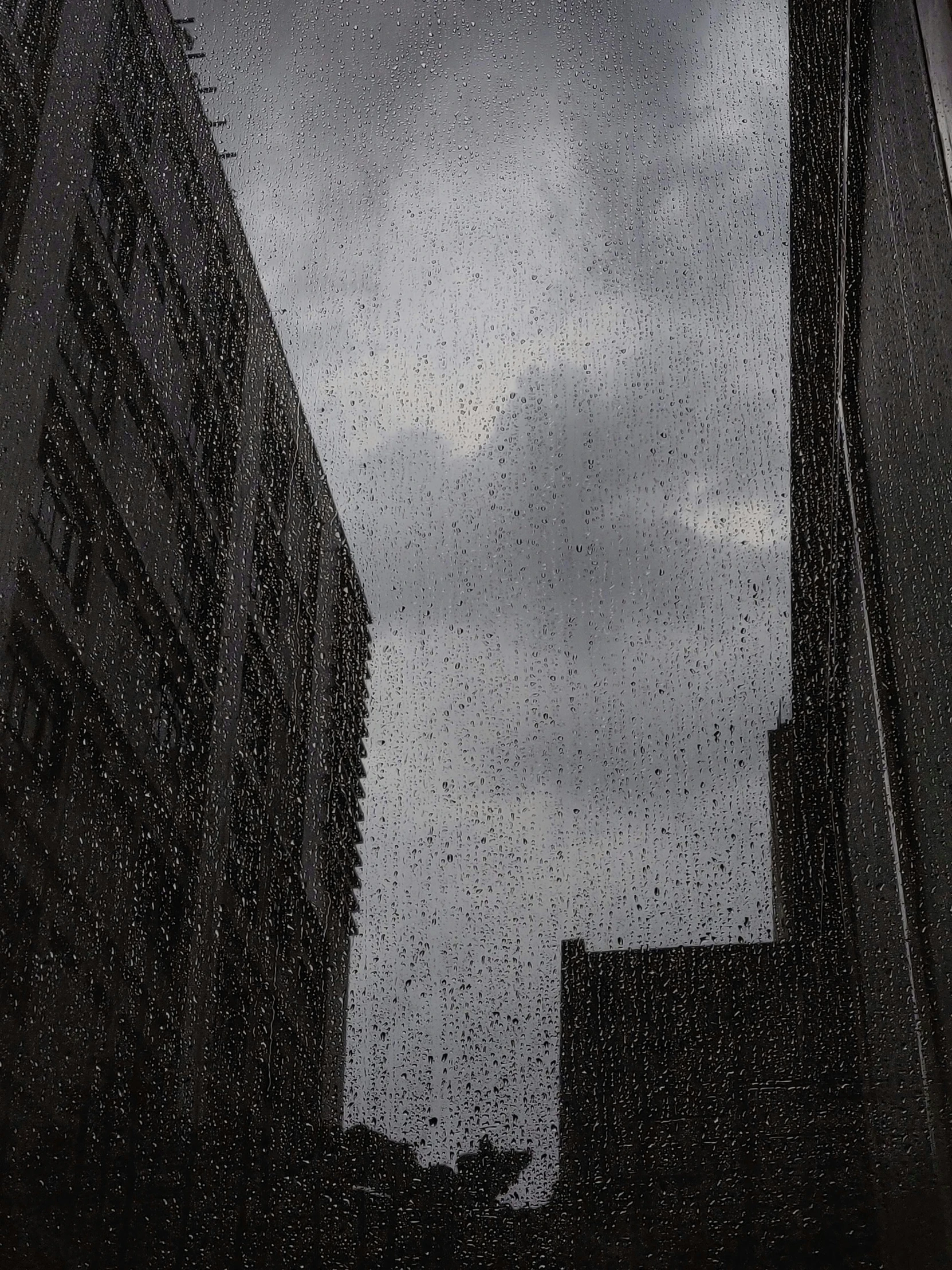 a rain soaked window with buildings in the background, inspired by Thomas Struth, photorealism, the sky is gray, lena oxton, depressing image, it's getting dark