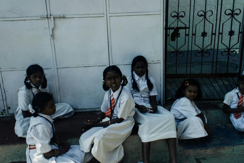 a group of young girls sitting next to each other, pexels contest winner, bengal school of art, white uniform, private academy entrance, ignant, high light on the left