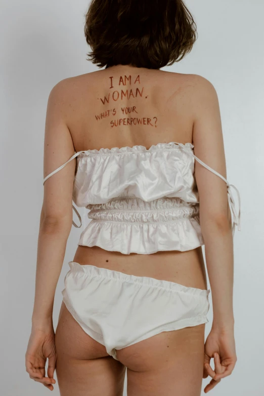 a woman with a tattoo on her back, an album cover, inspired by Tracey Emin, reddit, hana alisa omer, croptop, showstudio, y2k aesthetic