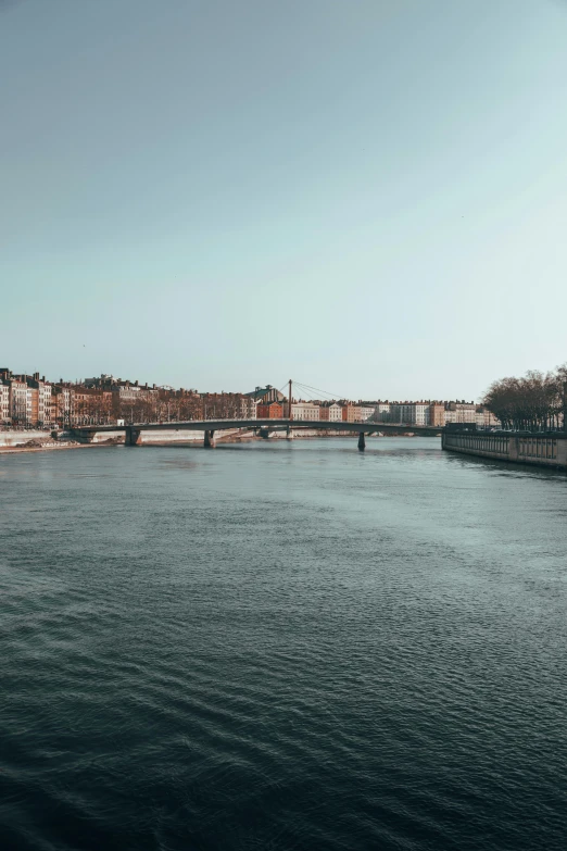 a river running through a city next to tall buildings, a picture, pexels contest winner, stockholm city portrait, wide long view, metallic bridge, traveling in france