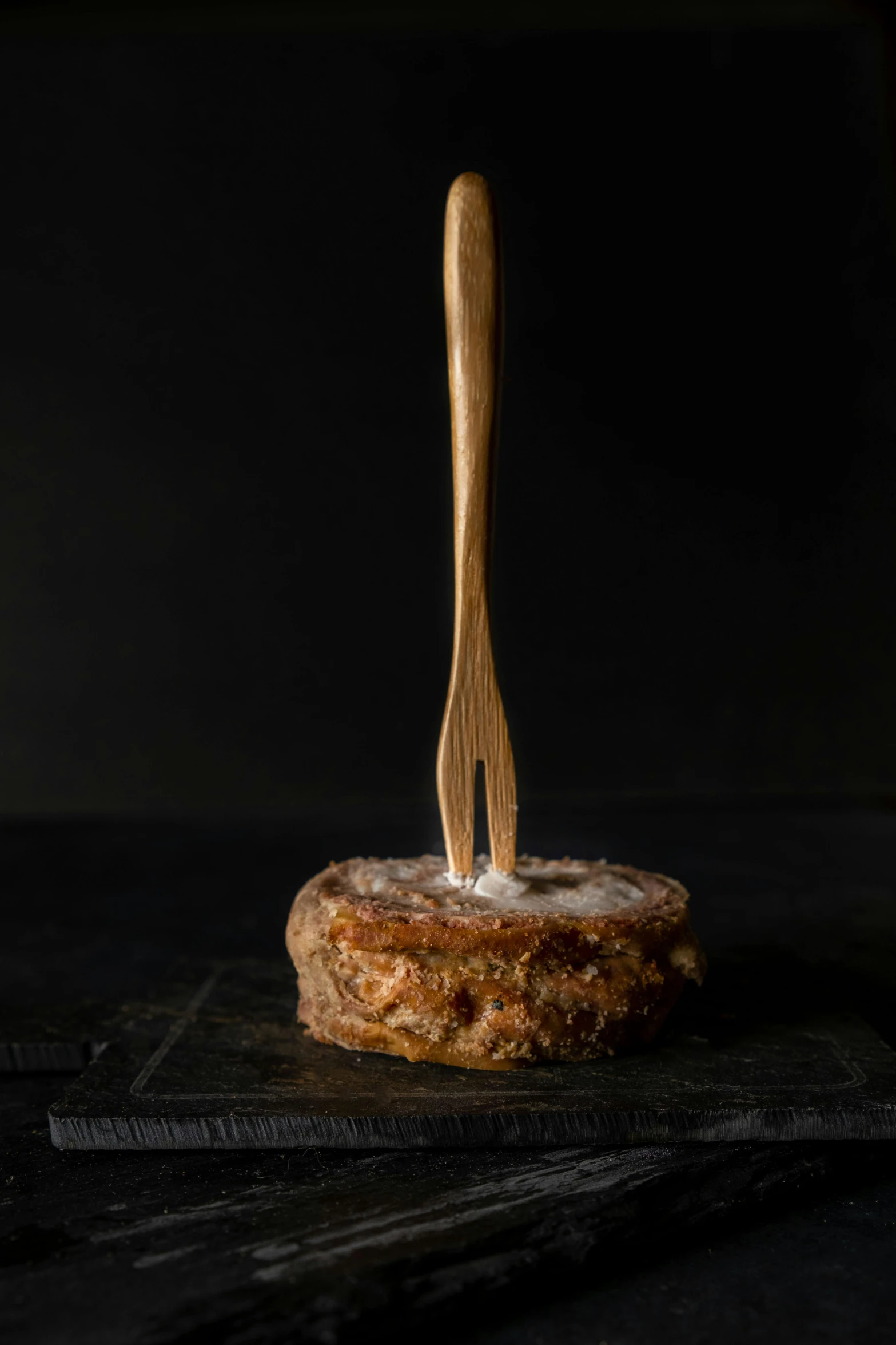 a donut with a fork sticking out of it, by Matthias Stom, pouring, steak, with a black background, ignant