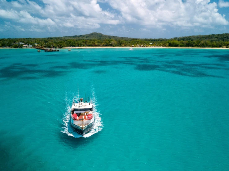 a boat in the middle of a large body of water, happening, australian beach, light blue water, birdeye, conde nast traveler photo