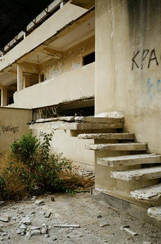 a building that has some graffiti on it, an album cover, by Mathias Kollros, in ruined agora of athens, outdoor staircase, military base, abandoned mall in the 1 9 8 0 s