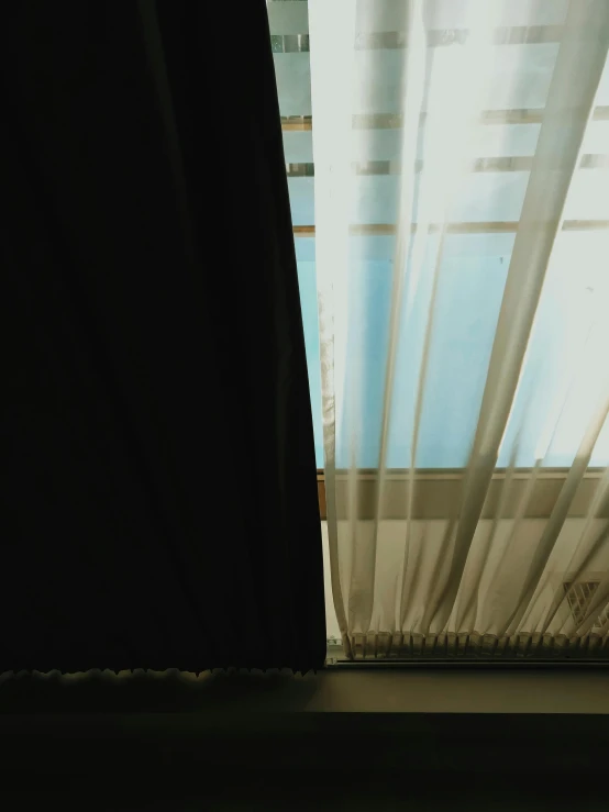 a cat sitting on a window sill in front of a curtain, an album cover, inspired by Elsa Bleda, unsplash, realism, ignant, hotel room, rinko kawauchi, real details