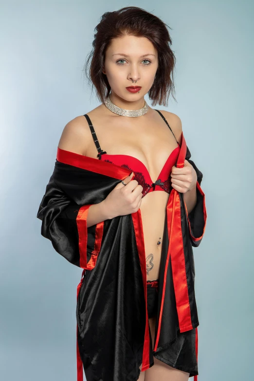 a woman in lingerie posing for a picture, an album cover, inspired by Torii Kiyonobu I, reddit, red and black cape and hoodie, close - up studio photo, ((wearing aristocrat robe)), anna nikonova aka newmilky