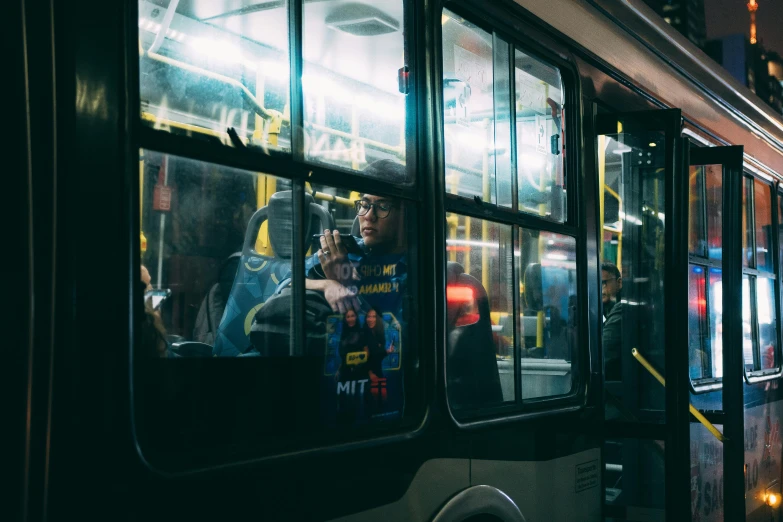 a bus driving down a city street at night, by Adam Marczyński, pexels contest winner, hyperrealism, looking at his phone, avatar image, people, mrt