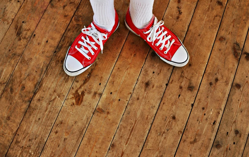 a person standing on a wooden floor wearing red sneakers, inspired by Kurt Trampedach, antipodeans, aged 13, istock, photo for magazine, wheres wally