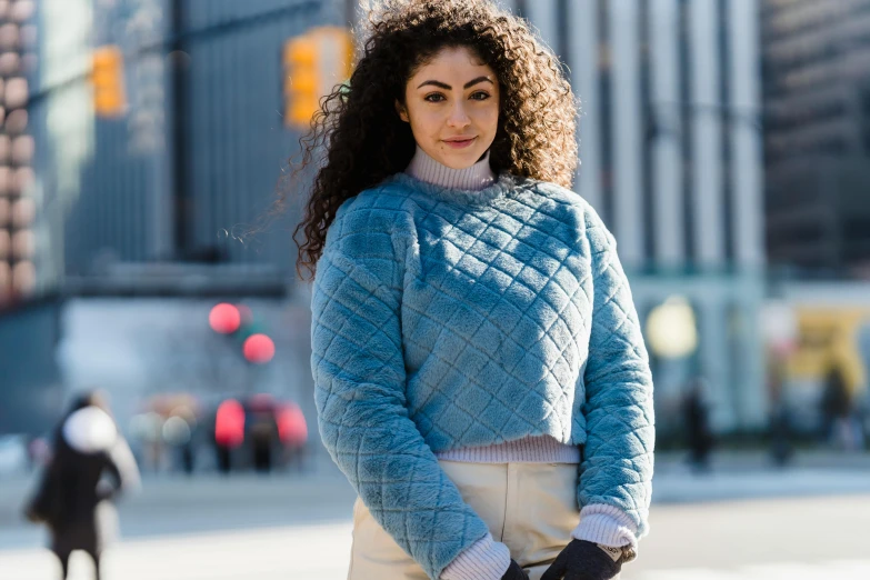 a woman in a blue sweater and white skirt, inspired by Anita Malfatti, trending on pexels, renaissance, square, curly haired, wearing a track suit, humans of new york