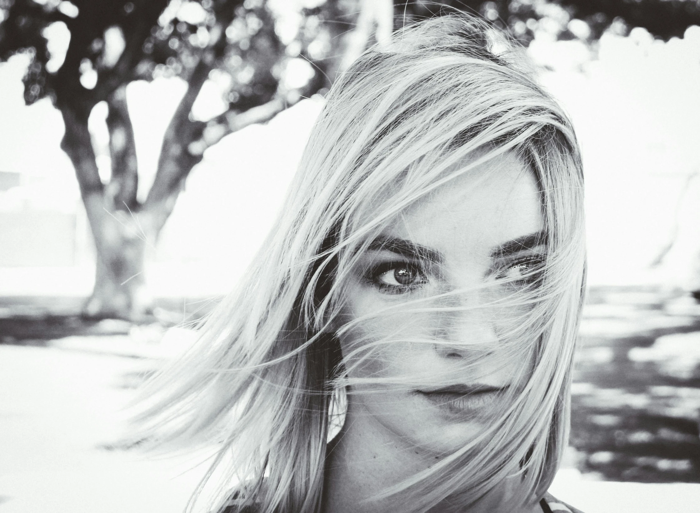 a black and white photo of a woman with her hair blowing in the wind, yvonne strahovski, with instagram filters, girl with white eyes, blur focus