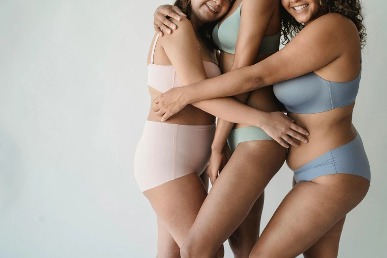 a group of three women standing next to each other, by Matija Jama, trending on pexels, blue undergarments, pastel pink skin tone, hugging her knees, silicone skin