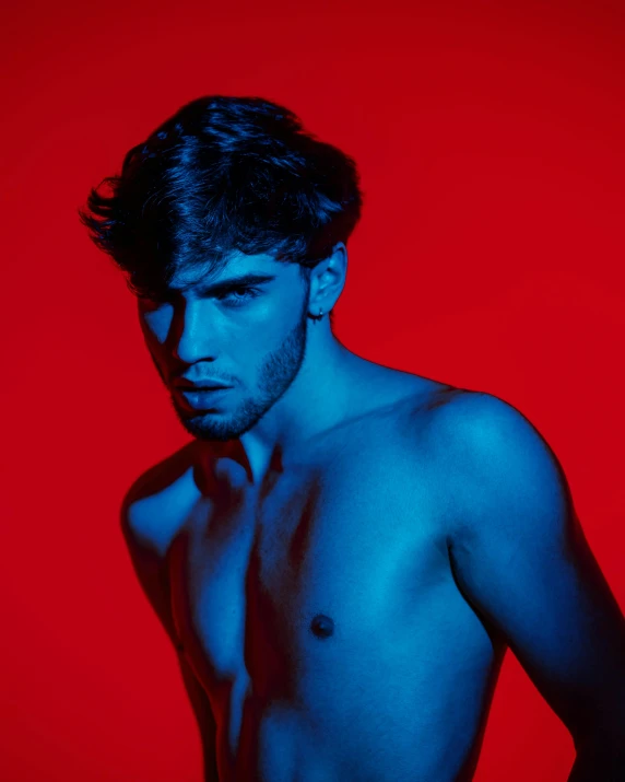 a shirtless man standing in front of a red background, an album cover, by Adam Dario Keel, trending on pexels, red and blue neon, diego fernandez, profile image, an epic non - binary model