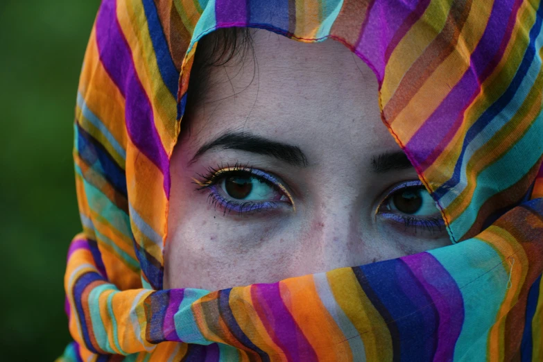 a close up of a person wearing a colorful scarf, a colorized photo, pexels contest winner, caucasian eyes, middle eastern, provocative indian, looking at you