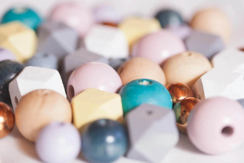 a pile of wooden beads sitting on top of a table, inspired by Perle Fine, trending on pexels, nordic pastel colors, seraphine, blocks, bottom body close up