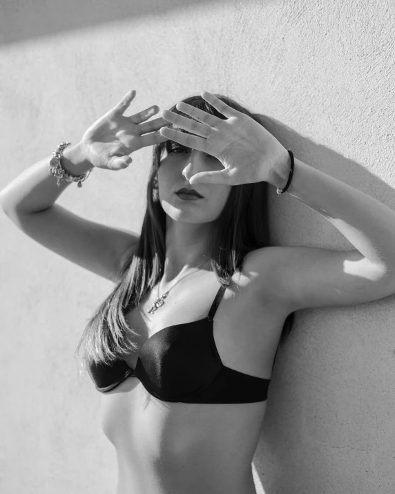 a black and white photo of a woman in a bikini, a black and white photo, unsplash, surrealism, hear no evil, photo of a hand jewellery model, waiting behind a wall, wearing shades