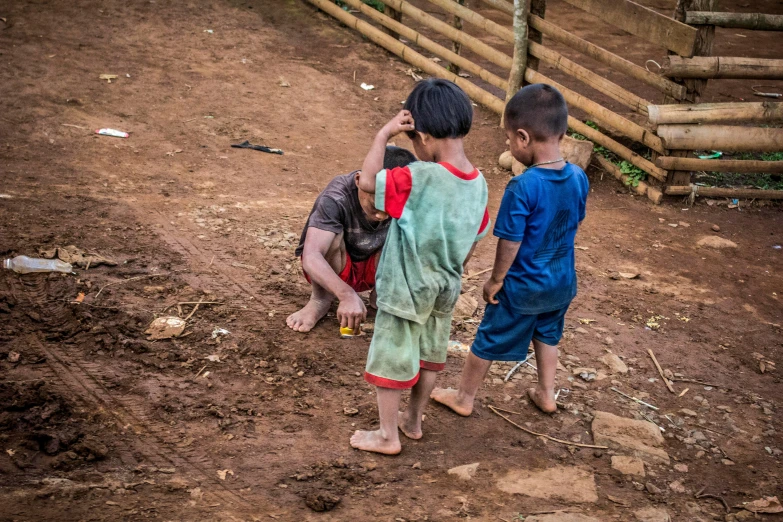 a group of children standing on top of a dirt field, laos, street photo, fan favorite, crawling on the ground