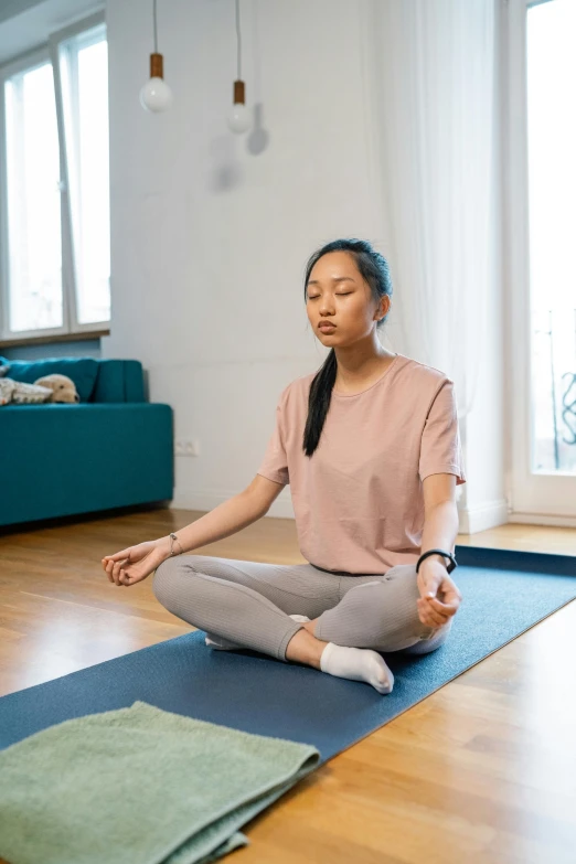a woman sitting on a yoga mat in a living room, by Dan Content, pexels contest winner, renaissance, cai xukun, breathing, promo image, low quality photo