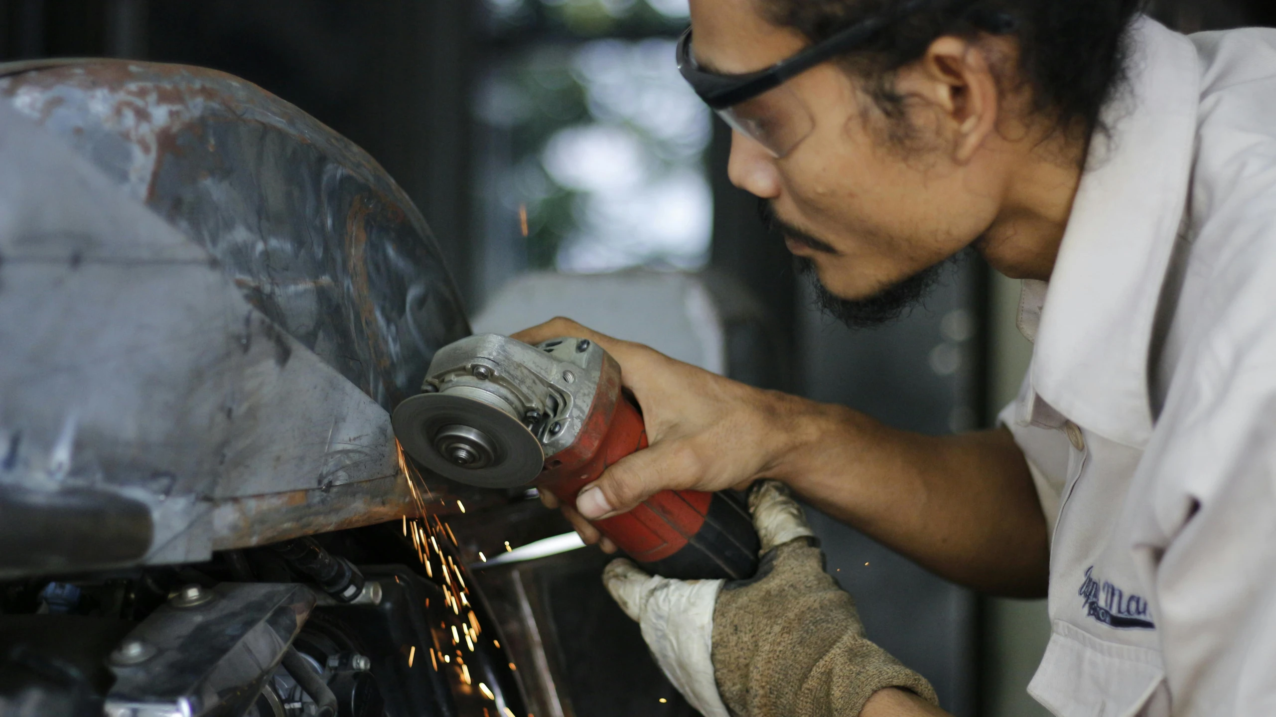 a man working on a motorcycle with a grinder, pexels contest winner, arbeitsrat für kunst, malaysian, avatar image, steel plating, profile picture