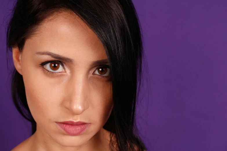 a woman posing for a picture in front of a purple background, trending on pexels, hurufiyya, big brown eyes, taken in the late 2010s, close - up studio photo, pouty face