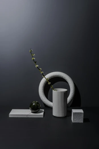 a vase that is sitting on a table, an abstract sculpture, inspired by Robert Mapplethorpe, unsplash, concrete art, statue of a cubes and rings, still life of white xenomorph, curated collections, dark vignette
