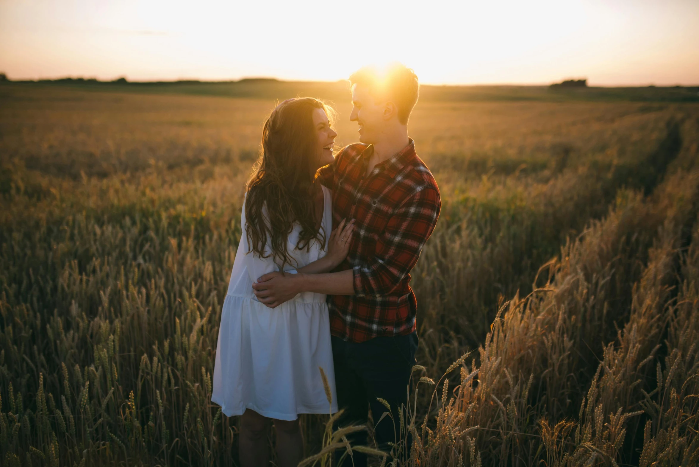 a couple standing in a field at sunset, pexels contest winner, attractive girl, white, owen klatte, in a sunbeam