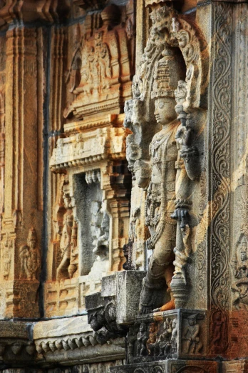 a close up of a statue on the side of a building, a statue, inspired by Thota Vaikuntham, ornate city ruins, in the center of the image, tall stone spires, vivid contrasts
