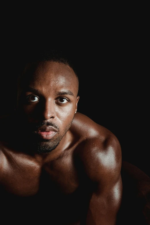 a man posing for a picture in the dark, an album cover, inspired by Leonard Daniels, athletic muscle tone, soulful eyes, yasuke 5 0 0 px models, african jesse pinkman portrait