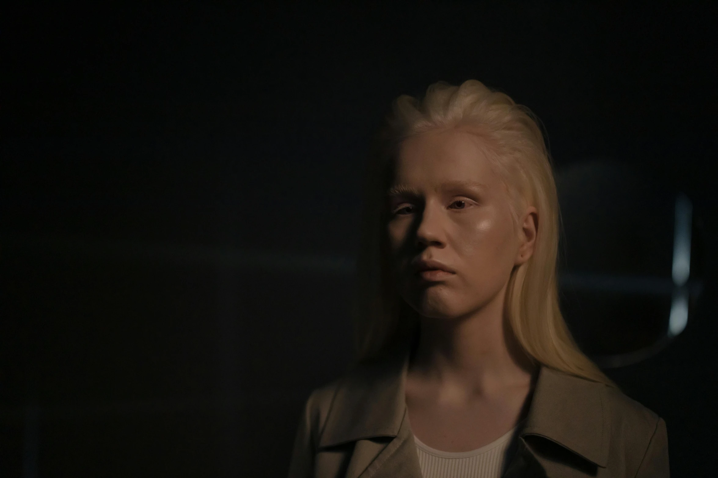 a woman with blonde hair standing in a dark room, a hologram, inspired by Louisa Matthíasdóttir, albino skin, her face is coated in a whitish, production still, 2077