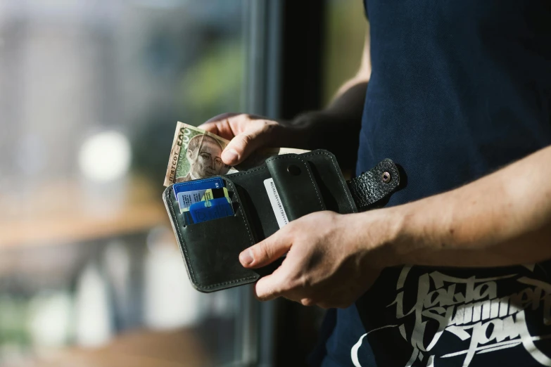 a close up of a person holding a wallet, by Niko Henrichon, unsplash, private press, square, australian, three quater notes, detailed scene