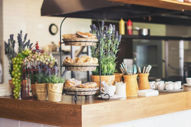 a bunch of food sitting on top of a counter, inspired by Richmond Barthé, unsplash, cafe interior, bakery, lavander and yellow color scheme, rustic wood