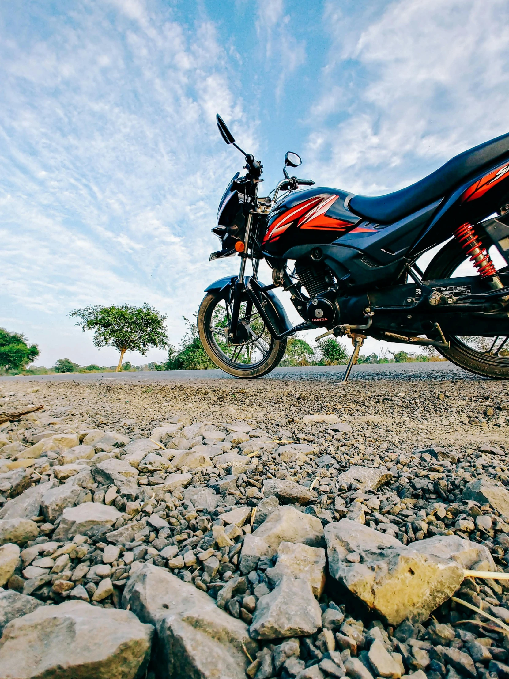 a motorcycle parked on the side of the road, pexels contest winner, gravels around, avatar image, ground view shot, details and vivid colors